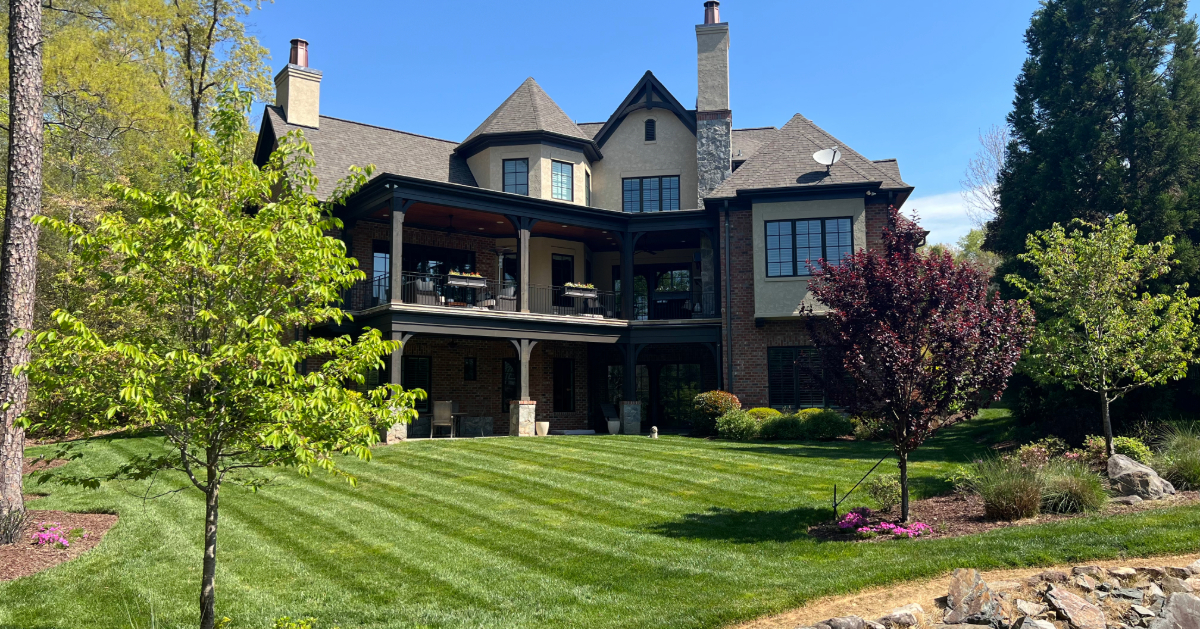 a large house with a lawn and trees top lawn care Outdoor Concepts Turf Management